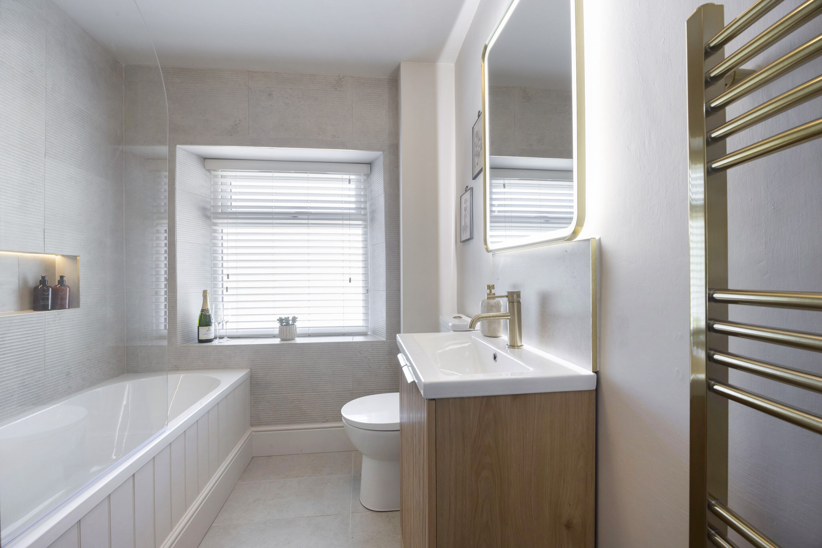A modern bathroom with a bathtub, toilet, and sink.