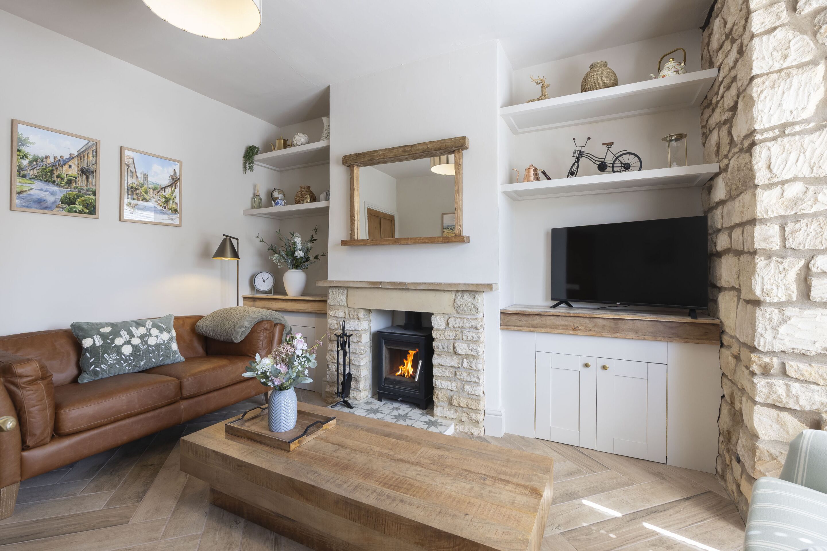 Ein Wohnzimmer mit Kamin, Fernseher, Sofa und Dekoration.