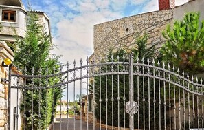 A wrought iron gate with a curved top, leading to a paved driveway. - Awesome home in Marcana (Marcana)