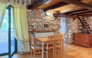 A rustic room with a stone wall, wooden furniture, a wooden table, and a staircase. - Awesome home in Marcana (Marcana)