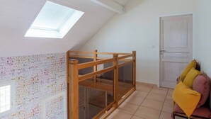 A room with a sloped ceiling, a skylight, a wooden partition, a door, and a couch with cushions. - House Flaura - Lake View - Veyrier - 3 bedrooms (Veyrier-du-Lac)