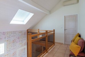 A room with a sloped ceiling, a skylight, a wooden partition, a door, and a couch with cushions. - House Flaura - Lake View - Veyrier - 3 bedrooms (Veyrier-du-Lac)