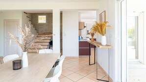 A modern kitchen with a wooden countertop, a dining table with chairs, and a staircase leading to another level. - House Flaura - Lake View - Veyrier - 3 bedrooms (Veyrier-du-Lac)
