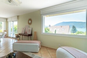 A room with a large window, a bed, a table, and a chair. - House Flaura - Lake View - Veyrier - 3 bedrooms (Veyrier-du-Lac)