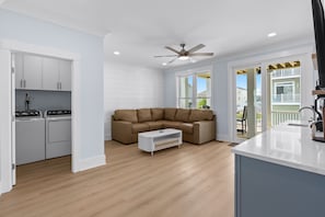 Eine moderne Küche mit weißen Schränken, einem eingebauten Backofen und einem Deckenventilator.