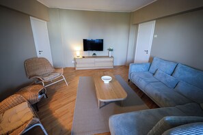 A living room with a television, a sofa, a chair, and a coffee table. - Central PENTHOUSE Unirii - FREE
PARKING (București)