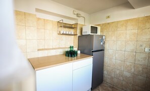 A compact kitchen with a microwave, refrigerator, and a shelf with cups. - Central PENTHOUSE Unirii - FREE
PARKING (București)