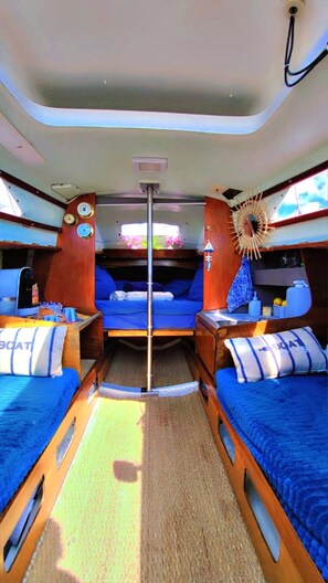 A compact interior with two bunk beds, a central aisle, and a decorative sunburst light fixture.