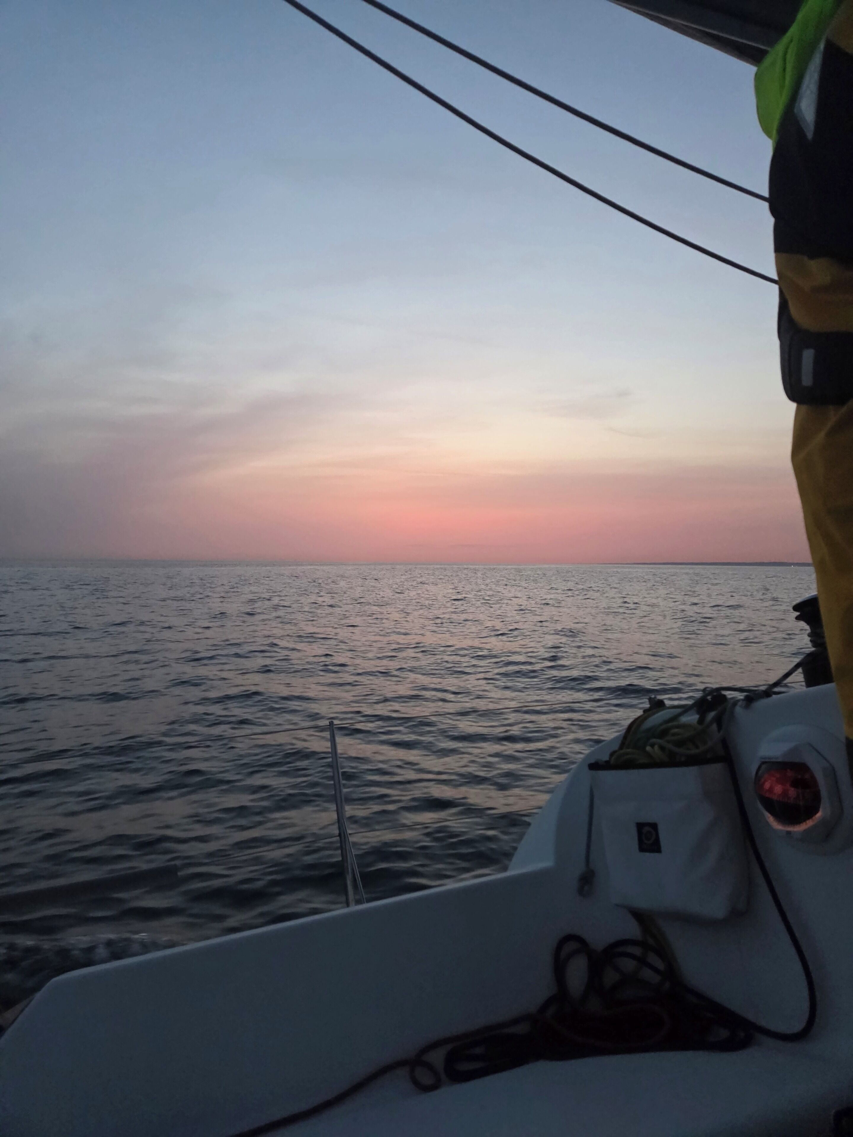 A boat's interior with a view of the sea and a sunset.