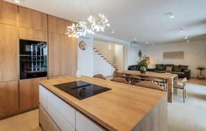 Eine moderne Küche mit Kochinsel, Holzschränken und integrierten Bosch-Geräten.