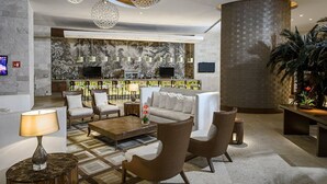 A lobby with a bar area, seating arrangements, and a large decorative wall. - The Grand Bliss Nuevo Vallarta Resort 2 bedrooms and AC at Vidanta Resort (Nayarit.)