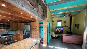 Una cocina con una isla central, un refrigerador y un microondas.