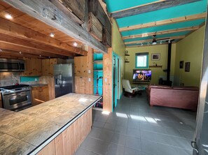 Eine Küche mit einer zentralen Kochinsel, einem Kühlschrank und einer Mikrowelle.