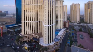 A multi-story hotel with a central courtyard, surrounded by other buildings.
