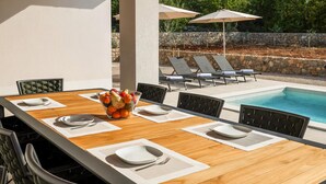 A dining table with white placemats, a fruit bowl, and black chairs with woven backs. - Pet friendly home in Krk (Krk)