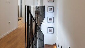 A staircase with black railings, a wooden floor, and framed pictures on the wall. - Pet friendly home in Krk (Krk)