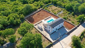 A white building with a swimming pool and solar panels, surrounded by dense greenery. - Pet friendly home in Krk (Krk)