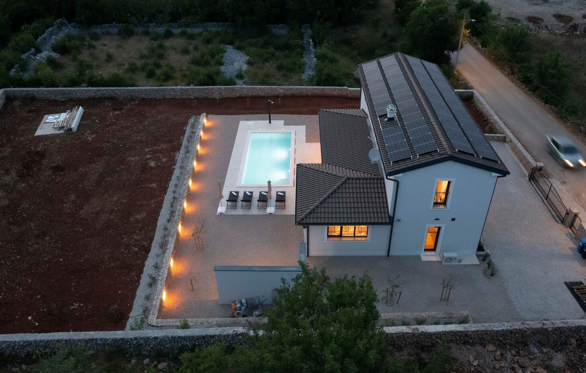 Una propiedad residencial con piscina, una casa y una carretera.