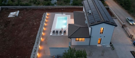 Una propiedad residencial con piscina, una casa y una carretera.