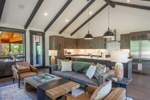 A modern kitchen with wooden cabinets, a central island, and pendant lighting. - Ultra-Luxury Mountain Retreat w/ Sauna & Hot Tub | Summit Sky Ranch (Silverthorne)
