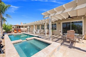 A pool area with lounge chairs and a pergola.