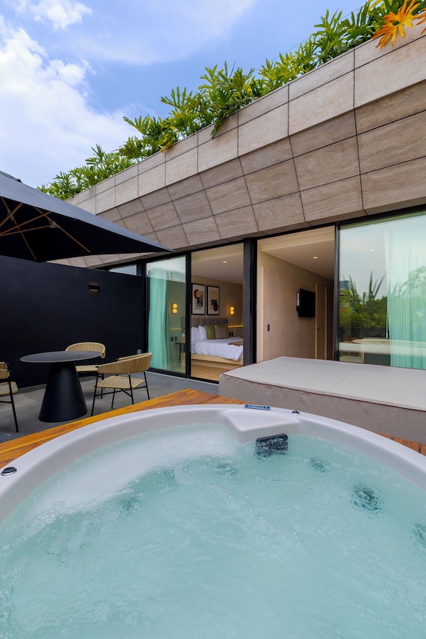 Uma área moderna com hidromassagem ao ar livre, com vista para um quarto e uma sala de jantar.