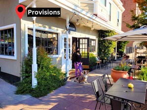 A restaurant named "Provisions" with outdoor seating and a dog on a leash.