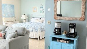 Un dormitorio con cama, cómoda, cafetera y espejo.