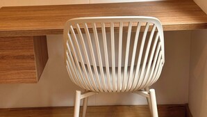 A white chair with a slatted back design, positioned in front of a wooden desk with a built-in drawer. - Premium Village 24 7 Security Balcony Fast Wifi (Medellín)