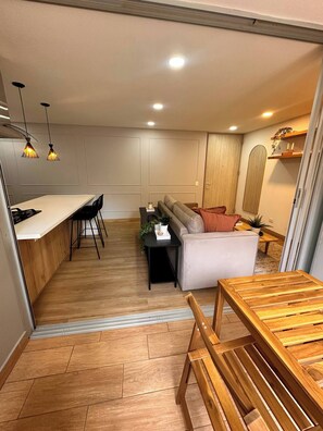 Una cocina moderna con comedor, sofá y mesa de madera.