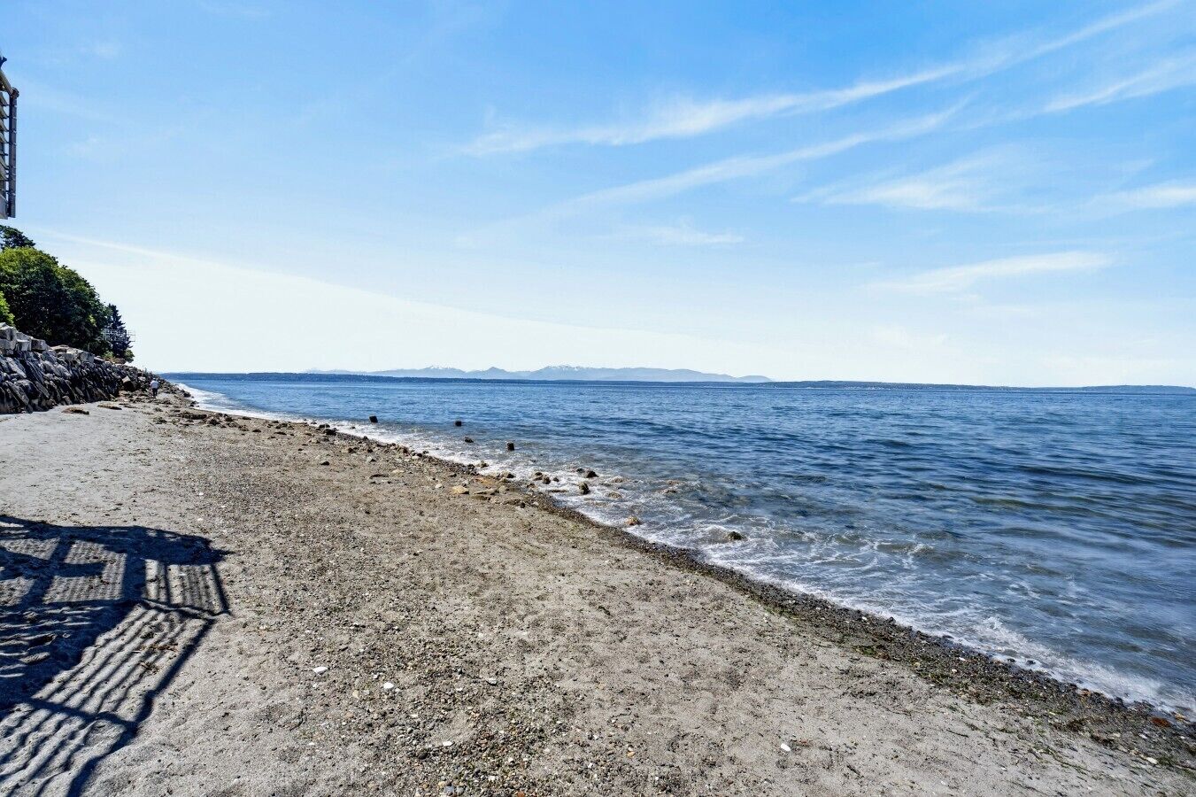 A beach with a rocky shoreline and a clear view of the sea.