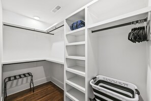A walk-in closet with white shelving, a metal rack, and a black and white storage bin. - Nice 3-bedroom house in Wilmington perfect for your getaway (Wilmington)