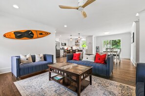A modern living room with a blue sofa set, a wooden coffee table, and a ceiling fan. - Nice 3-bedroom house in Wilmington perfect for your getaway (Wilmington)