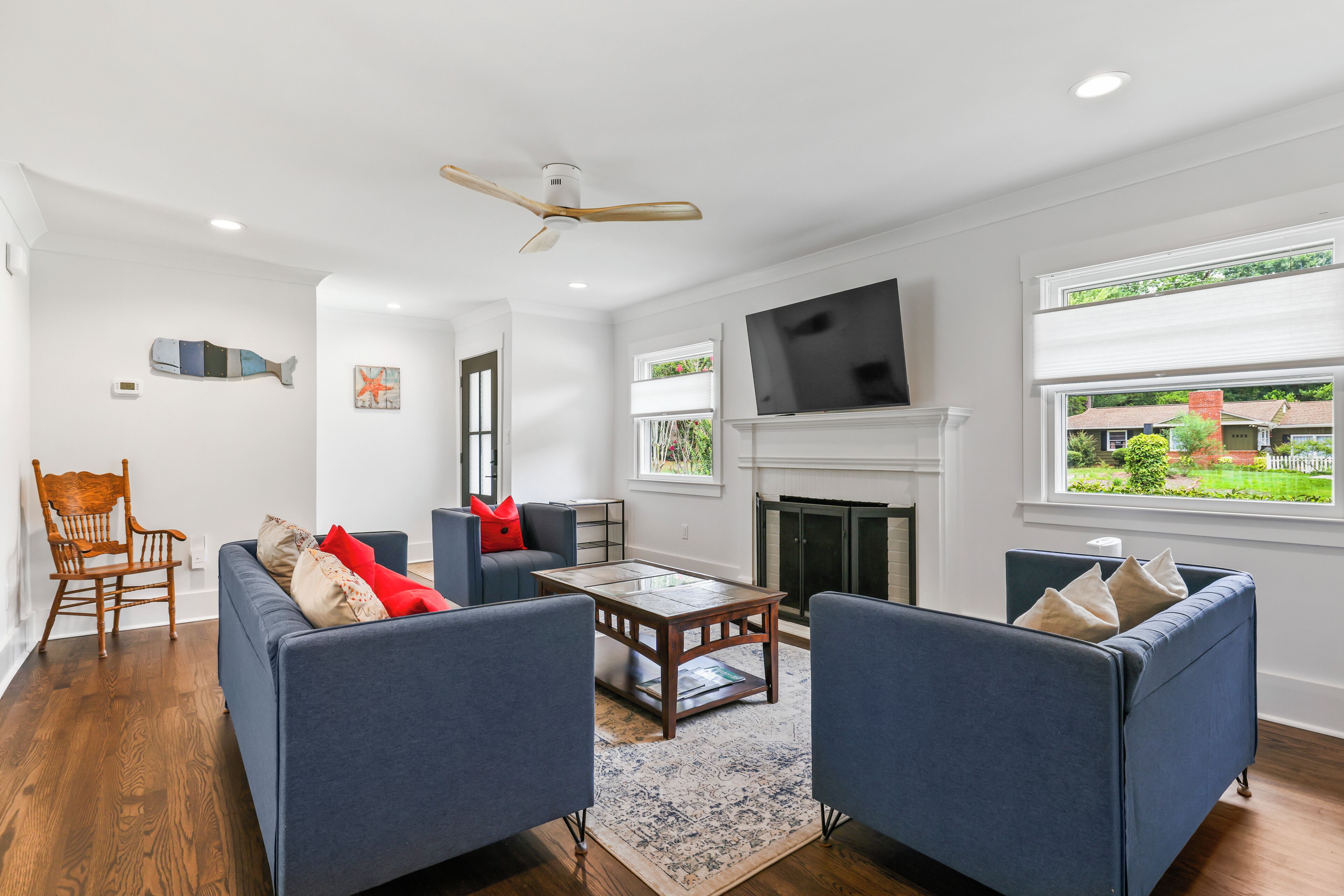 A modern living room with a fireplace, two sofas, a coffee table, and a television.