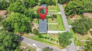 An aerial view of a residential area with a house, a driveway, and surrounding greenery. - Nice 3-bedroom house in Wilmington perfect for your getaway (Wilmington)