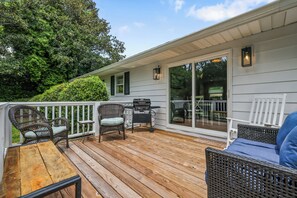 A covered deck with wicker furniture, a grill, and a view of the backyard. - Nice 3-bedroom house in Wilmington perfect for your getaway (Wilmington)