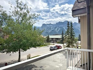 Ein Balkon mit Blick auf eine Straße, Autos und Berge.