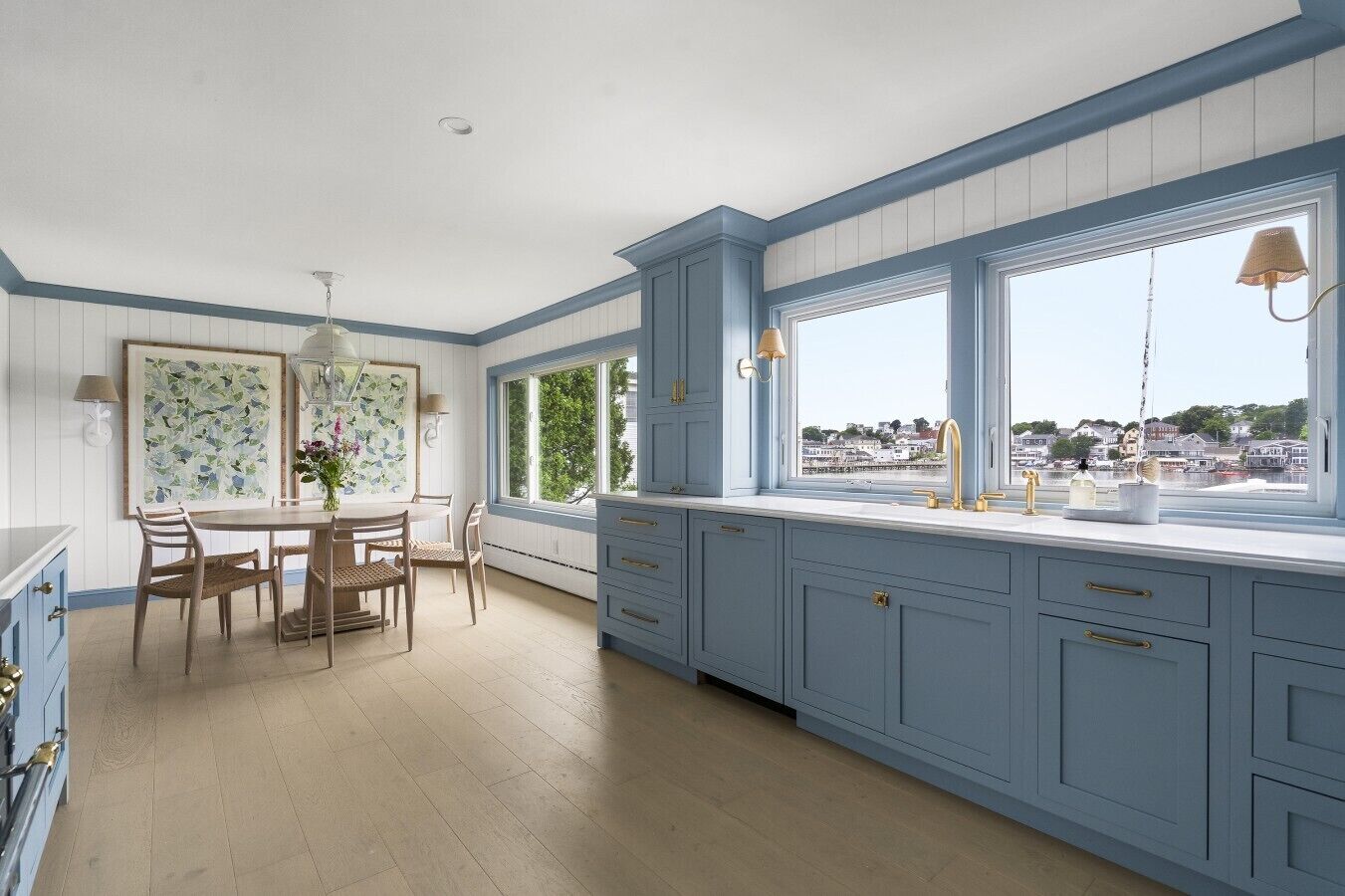 Una cocina con comedor, ventanas amplias y vista al agua.
