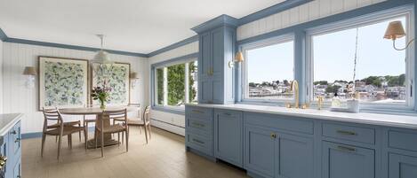 A kitchen with a dining area, large windows, and a view of the water.