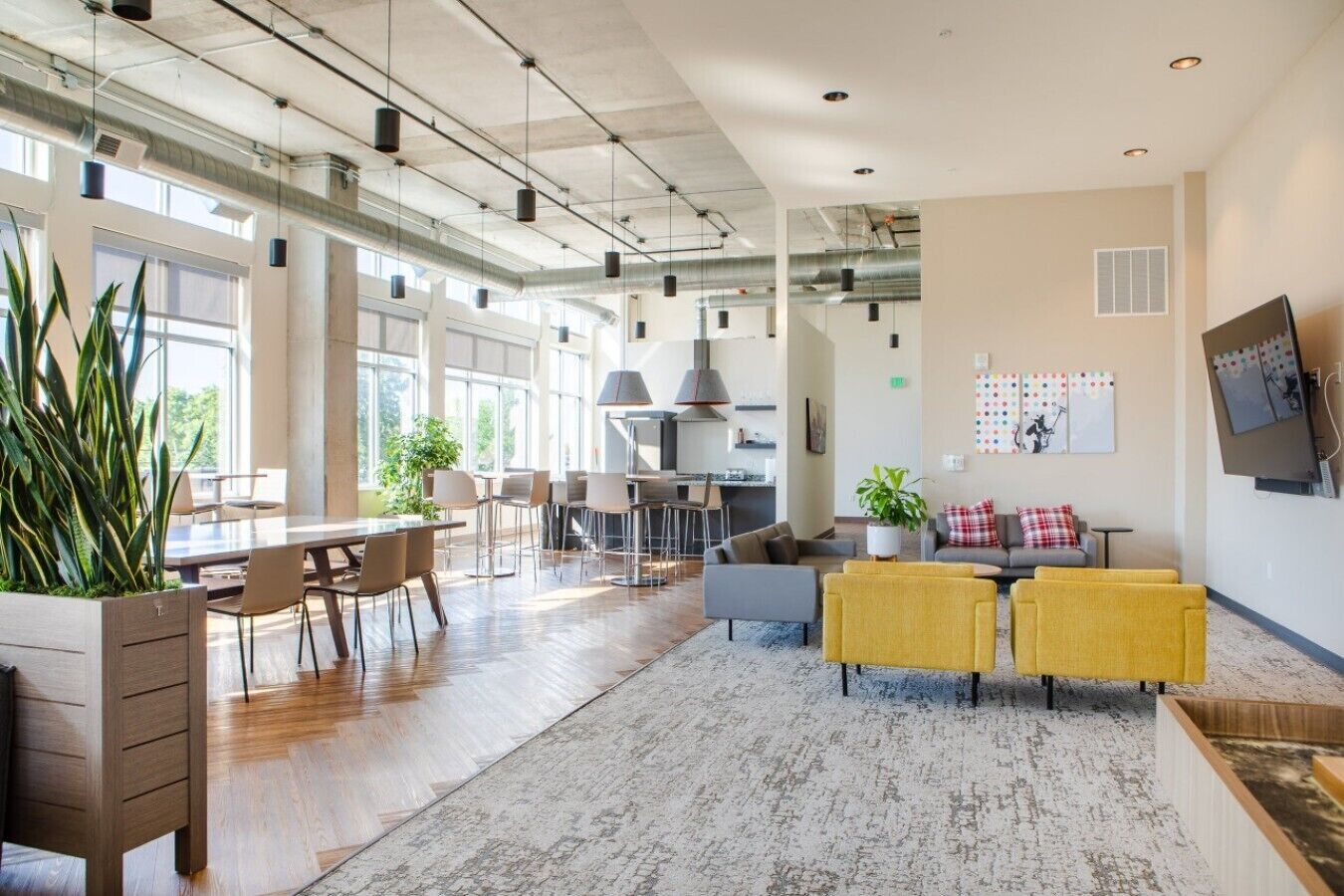 A spacious open-plan living area with a dining area, kitchen, and seating with a view of the outdoors.