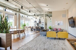 Un vaste espace de vie à aire ouverte comprenant un coin repas, une cuisine et un espace détente avec vue sur l’extérieur.