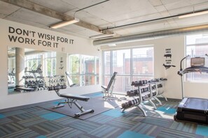 A gym with exercise equipment, large windows, and motivational wall text. - Luxury Penthouse Apt Near Brady St with Balcony and Lake View (Milwaukee)