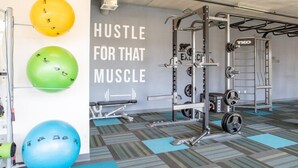 Ein Fitnessraum mit Trainingsgeräten, einer Wand mit motivierenden Texten und Übungsbällen.