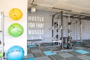 A gym with exercise equipment, a wall with motivational text, and exercise balls. - Luxury Penthouse Apt Near Brady St with Balcony and Lake View (Milwaukee)