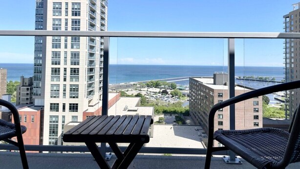Ein Balkon mit Blick auf das Meer, einem Tisch und zwei Stühlen.