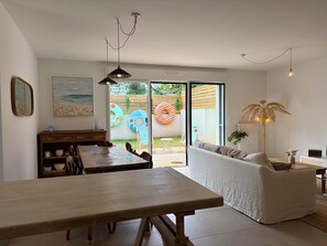 Ein modernes Interieur mit Essbereich, einer Couch und Blick auf den Garten.