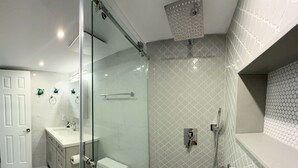 Ein modernes Badezimmer mit einer Duschkabine, einer Toilette und einem Waschbecken.