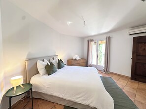 A bedroom with a bed, bedside table, nightstand, and a window with curtains. - Villa Océane. Spacious House with Swimming Pool – Pernes-les-Fontaines (Pernes-les-Fontaines)