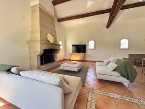 A living room with a fireplace, a television, and two sofas. - Villa Océane. Spacious House with Swimming Pool – Pernes-les-Fontaines (Pernes-les-Fontaines)