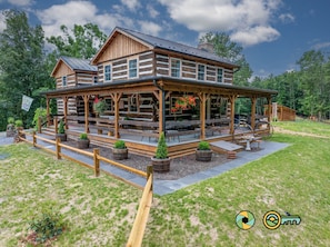 A log cabin with a porch, outdoor seating, and potted plants. - The Sawmill Inn - pre-Civil War luxury log cabin on 70+ private acres! (Mount Jackson)